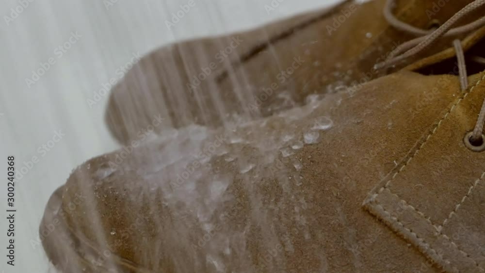 waterproof suede boots under heavy rain concept. watter roll of the shoes and don't absorb by surface. macro UHD 4k video footage