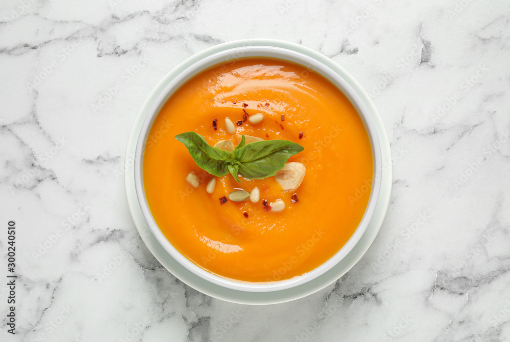 Delicious pumpkin soup in bowl on marble table, top view - obrazy, fototapety, plakaty 