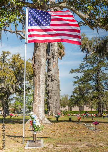 American flag at a headstone on an historic old cemetry in Savannah, Goergia photo