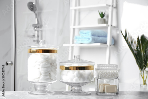 Cotton balls  swabs  pads and soap bars on light grey marble table in bathroom