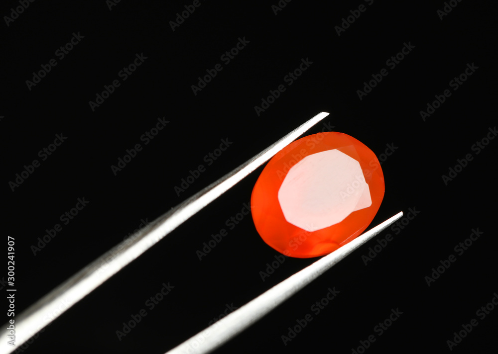Tweezers with beautiful gemstone on black background. Space for text Tweezers with beautiful gemstone on black background. Space for text
