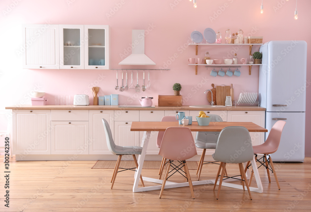 Stylish pink kitchen interior with dining table and chairs - obrazy, fototapety, plakaty 