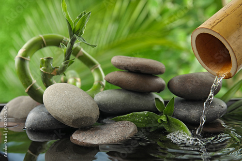 Photography Composition with stones and bamboo fountain against blurred background
