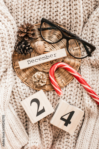 Winter composition. Cup with coffee, glasses, cones on a sweater background.