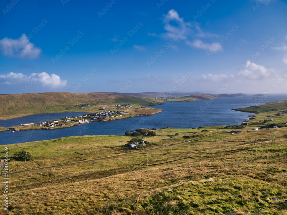A view of Weisdale Voe on the west of Mainland, Shetland, Scotland, UK, taken on a sunny day with a blue sky and light clouds the houses at Kalliness and the Loch of Hellister appear on the left.