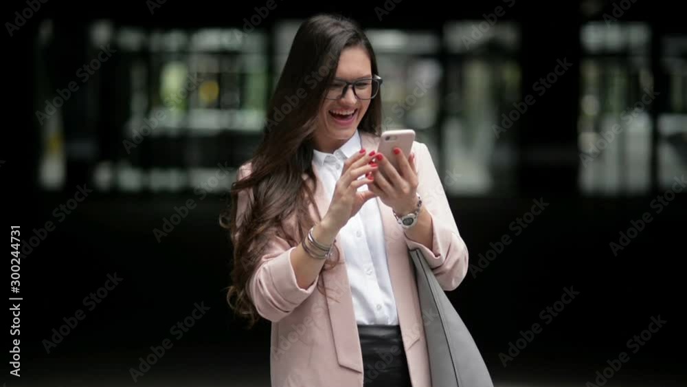 Happy Business Woman Uses a Smart Phone Standing in the Street. She Is Getting Good News. Phone Talking Happy Business Woman Uses a Smart Phone Standing in the Street. She Is Getting Good News. Phone Talking