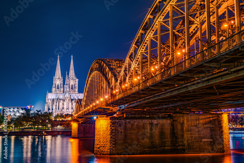 The Hohenzollern Bridge over the Rhine River and Cologne Cathedral by night