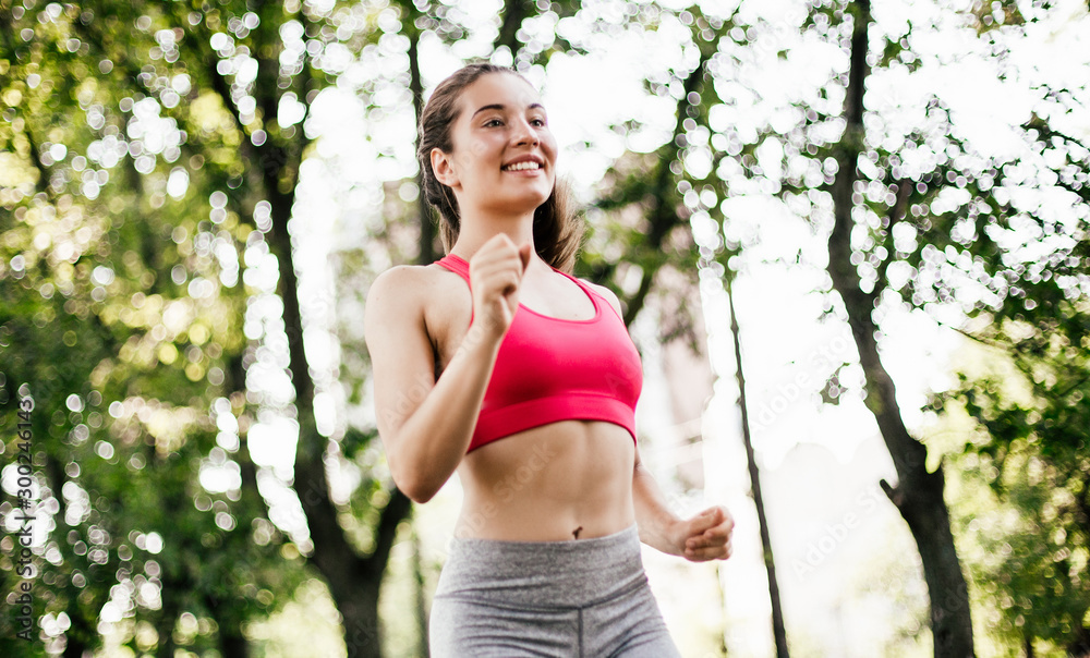 Young fitness woman running around in the park. Young fitness woman running around in the park.
