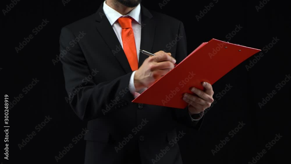 Man fills papers in red folder with pen, then looks through them. Concept of planning, business. Mockup ready for your text or product. Man fills papers in red folder with pen, then looks through them. Concept of planning, business. Mockup ready for your text or product.
