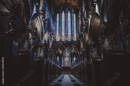 GLASGOW, SCOTLAND, DECEMBER 16, 2018: Magnificent perspective view of interiors of Glasgow Cathedral, known as High Kirk or St. Mungo, with huge stained glasses. Scottish Gothic architecture.