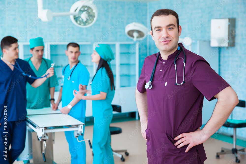 Obraz premium Portrait of a successful professional doctor. The staff of the medical faculty. multinational people - doctor, nurse and surgeon. A group of graduates of a medical university in a surgical room.
