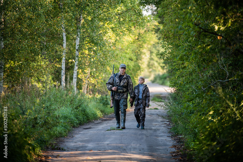 A ranger teaching his son about spotting the game in the wilderness