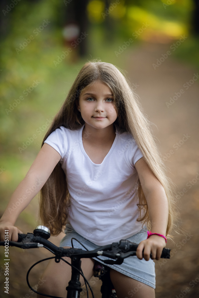 Little girl having fun on bike in the forest in autumn season Little girl having fun on bike in the forest in autumn season