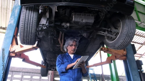 Wallpaper Mural Senior mechanic inspecting suspension car systems with digital tablet,maintenance and service Torontodigital.ca