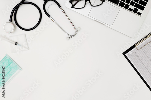 Wallpaper Mural Stethoscope, Top view of doctor's desk table, blank paper on white background, above view doctor work tools on white, Stethoscope, laptop, eyeglass and medical drug on white background,  Torontodigital.ca