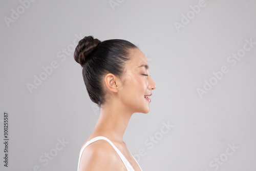 Side view of Beautiful Asian woman close eyes smile with clean and fresh skin Happiness and cheerful with positive emotional isolated on gray background Beauty and Cosmetics Concept