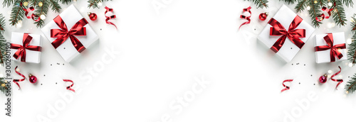 Creative frame made of Christmas fir branches, gift boxes, red decoration, sparkles and confetti on white background. Xmas and New Year holiday, bokeh, light. Flat lay, top view