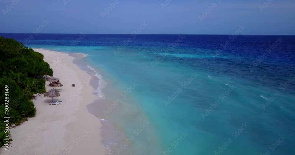 Remote exotic island with wide white beach and lush vegetation located far away, surrounded by mysterious ocean in Maldives Remote exotic island with wide white beach and lush vegetation located far away, surrounded by mysterious ocean in Maldives