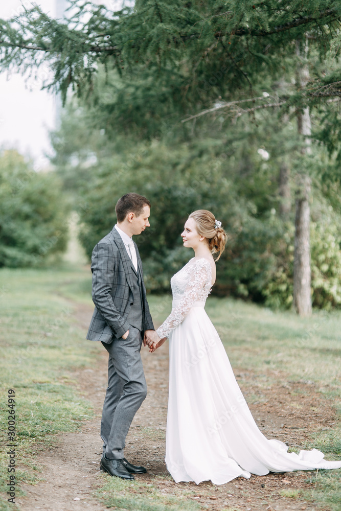 Modern ceremony in European style. Beautiful wedding couple in atmospheric forest with rocks.