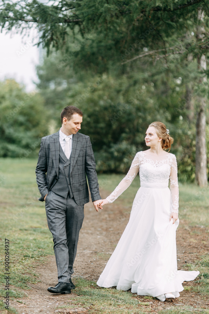 Modern ceremony in European style. Beautiful wedding couple in atmospheric forest with rocks.