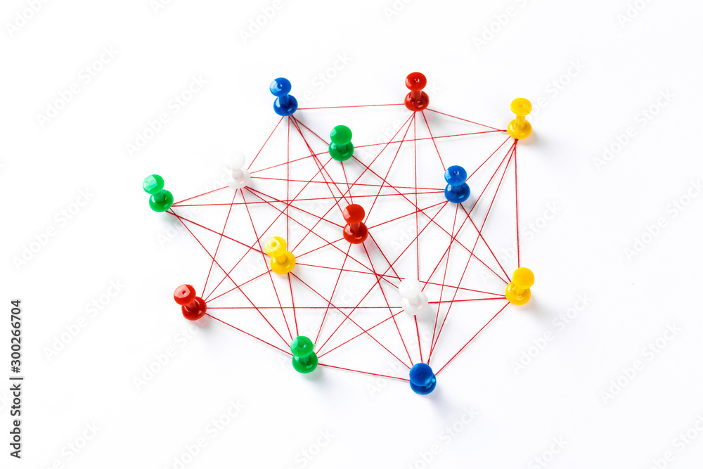 Fototapeta Sieć z kolorowymi pinami i sznurkiem, połączonym sznurkiem na białym tle sugerującym sieć połączeń.