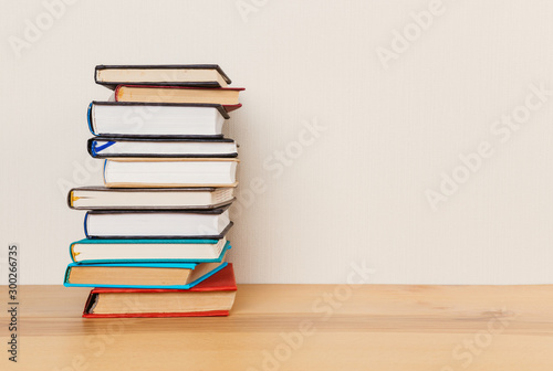 Simple composition of many hardback books  raw of books on wooden table and light  background