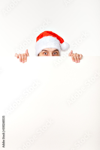 Santa man in christmas red hat for new year holiday with white paper sheet isolated on white background, copy space © satura_