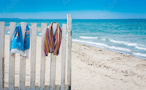 Fence with beach towels on the beach.