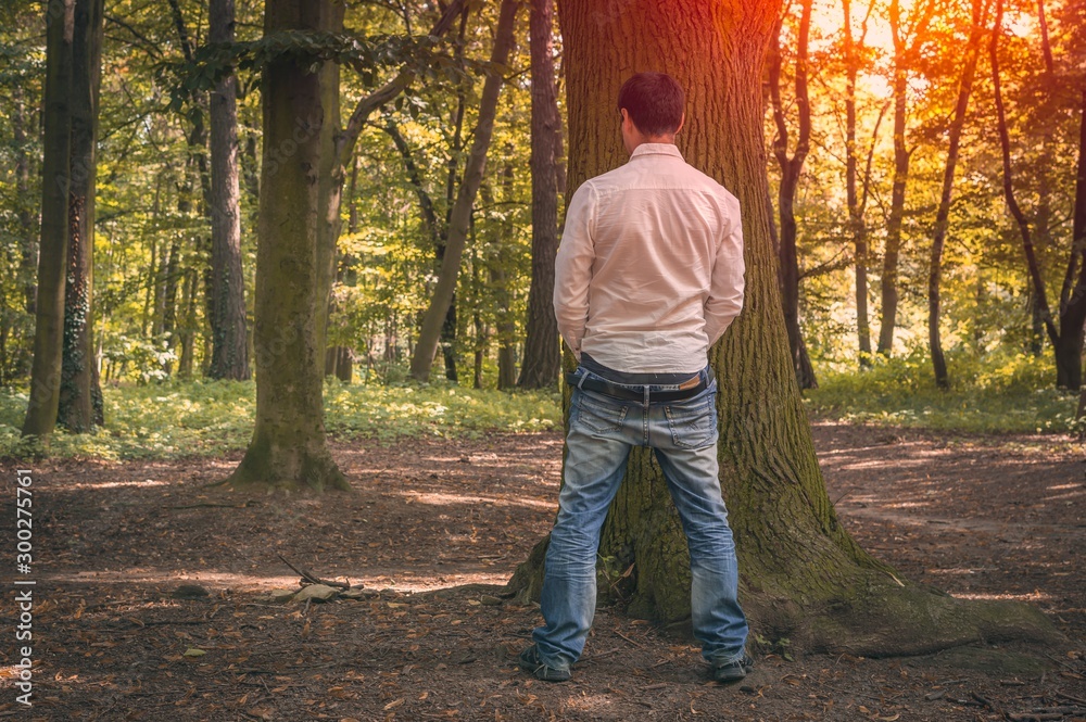 standing-man-peeing-near-big-tree-in-autumn-forest-stock-photo-adobe