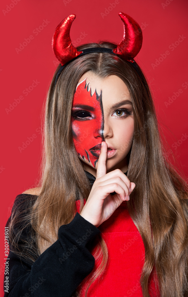 Devil. Funny imp with red horns and black bow tie at Halloween party. Halloween makeup. The devil costume. Stock Photo