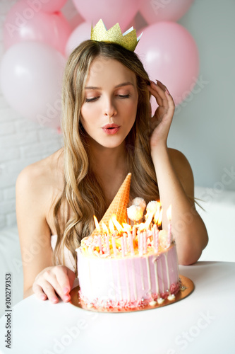 Happy pretty girl with cream cake and pink balloons at birthday party.  Barbie style. Princess.  16 years old girl.