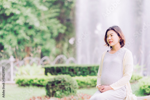 Happy pregnant woman relaxing outside in the park outdoor Free Download Happy pregnant woman relaxing outside in the park outdoor - GFXLoad