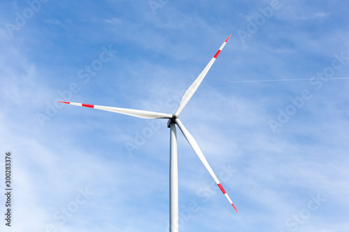 A windmill with a blue sky in the background