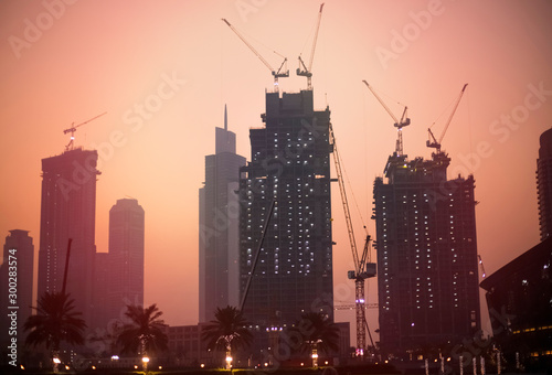 Fototapeta Naklejka Na Ścianę i Meble -  View of the city under construction in the evening against the sunset. toning