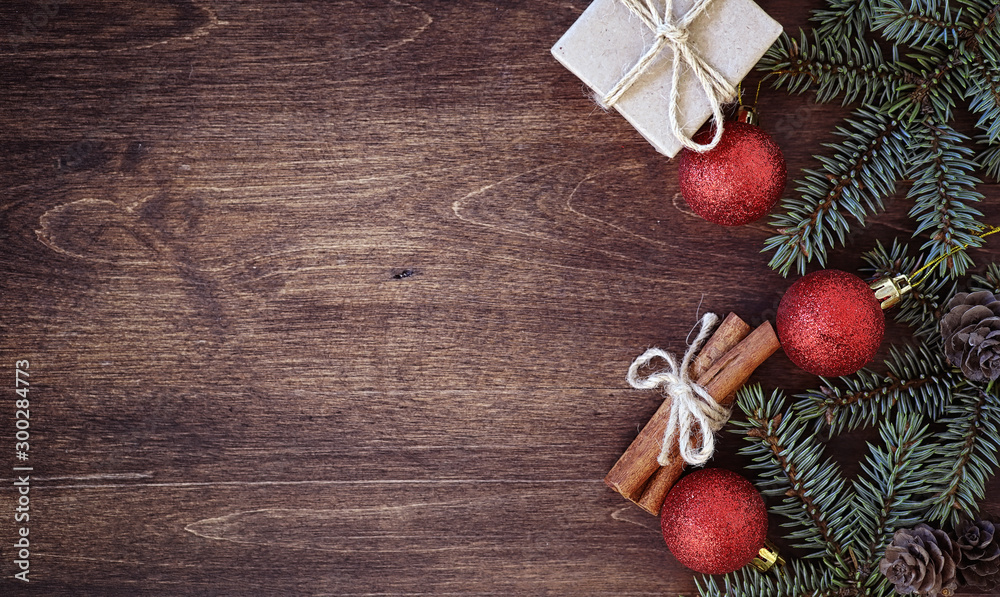 Obraz premium New Year's background. Spruce branches on a wooden table. Ornaments for the New Year tree. Christmas concept.