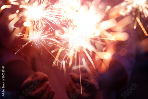 Hand of woman holding firework firework pyrotechnics and bokeh with blurry effect on the dark background for celebration concept