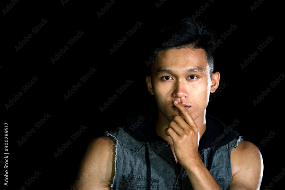 Portrait of young serious handsome boy with muscle on the black background Portrait of young serious handsome boy with muscle on the black background