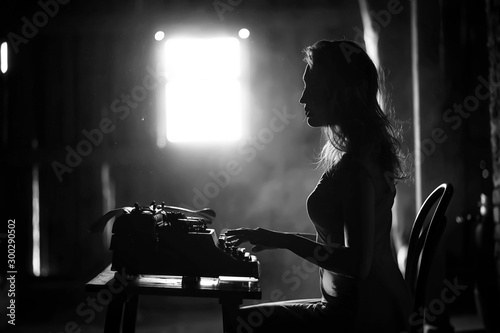 A girl prints on an old typewriter