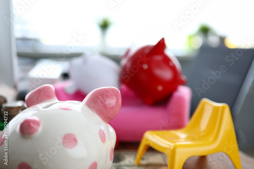 Piggy looking at two other piggies on couch photo