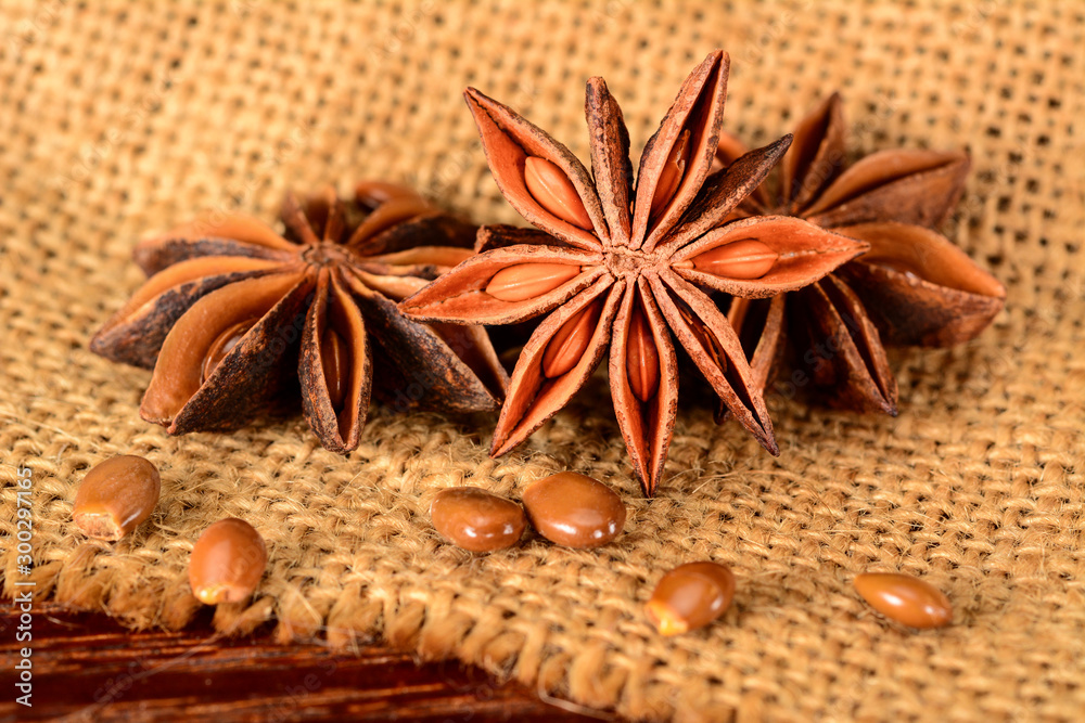 Star anise. Some star anise fruits with seeds. Macro close-up on jute burlap napkin in rustic style. Star anise. Some star anise fruits with seeds. Macro close-up on jute burlap napkin in rustic style.