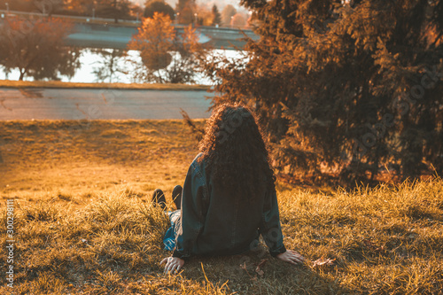 Young woman enjoying sunset time in the autumn park