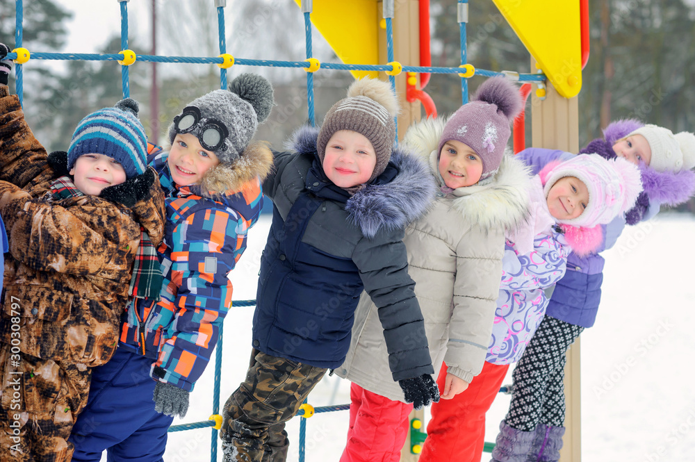 A group of children playing and having fun on a winter playground. Winter fun. holidays