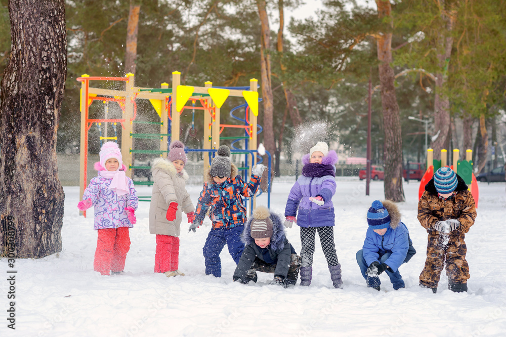 A group of children are playing and having fun on a winter playground. Throw snow and laugh. Winter fun. holidays
