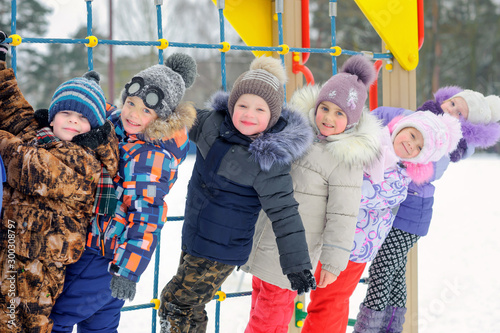 Obraz na płótnie A group of children playing and having fun on a winter playground. Winter fun. holidays w salonie