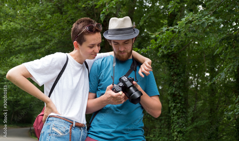 Couple take pictures on a walk in the forest Couple take pictures on a walk in the forest