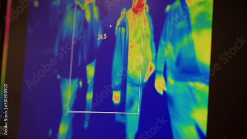 People on display of infrared thermometer heat sensor CCTV camera. Surveillance monitoring inspection concept. Screen of thermal heat-sensor with colored silhouettes. Heat radiation public space film