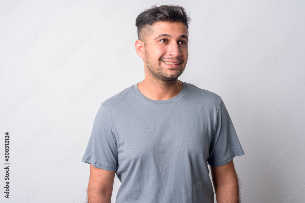 Portrait of happy young handsome Persian man thinking Portrait of happy young handsome Persian man thinking