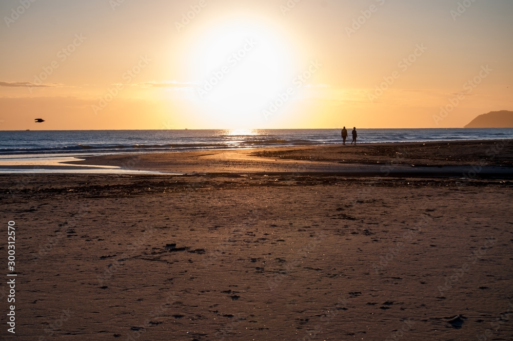 sunrise view and silhouette of couple walking on the beach sunrise view and silhouette of couple walking on the beach