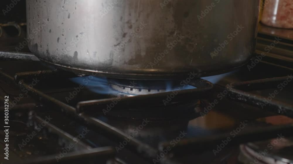 igniting a flame under a pan