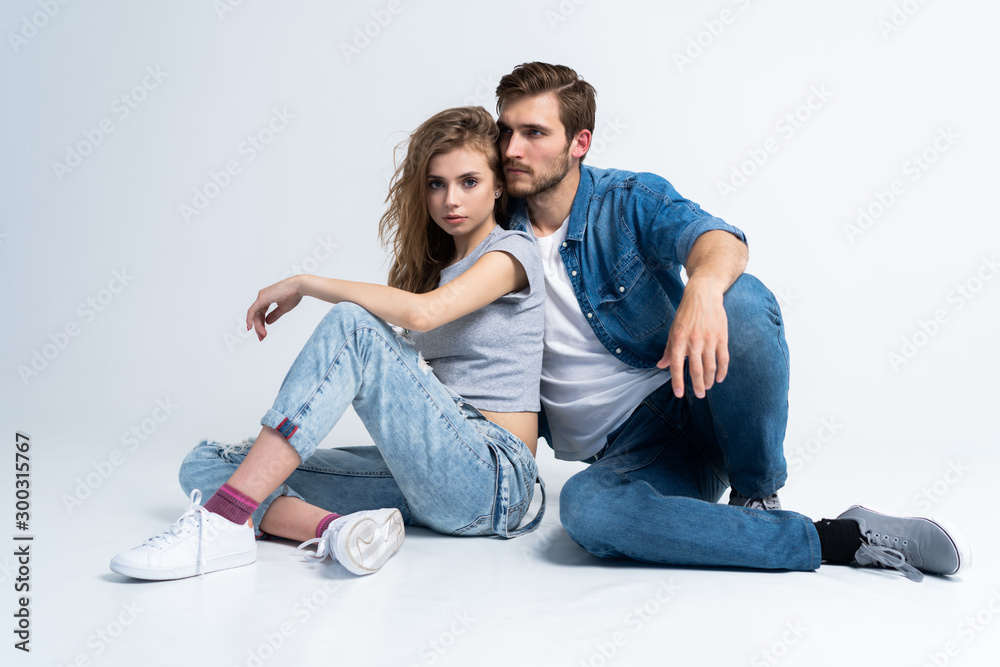 Portrait Of Happy Young Couple Sitting On Floor Leaning Against Wall Portrait Of Happy Young Couple Sitting On Floor Leaning Against Wall